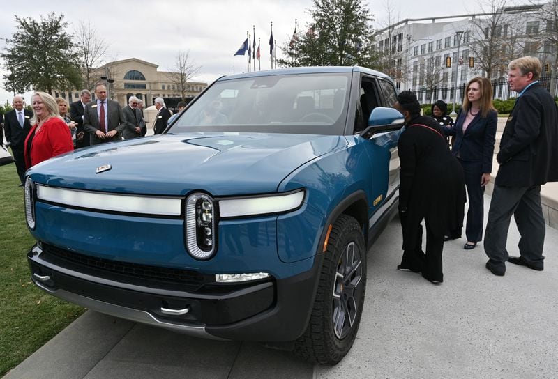 Guests look at a Rivian R1T truck during a Dec. 16 press conference announcing that the electric-vehicle makerplans to build a $5 billion assembly plant and battery factory in Georgia. (Hyosub Shin / Hyosub.Shin@ajc.com)