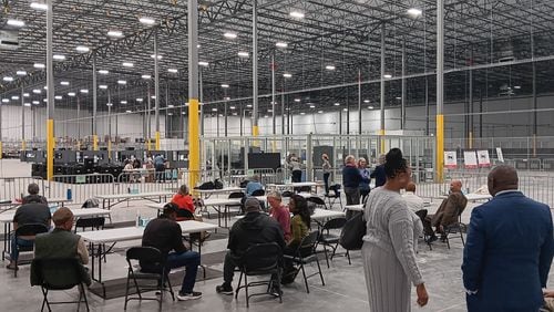 Observers and candidates watch county election staff from a public viewing area in the new Fulton elections warehouse in Union City. County workers are recounting results from the 2023 municipal elections.