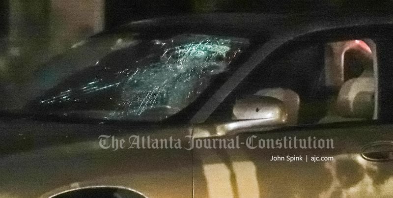 A vehicle with a shattered windshield was towed from the Manchester at Mansell apartment complex, where a fatal shooting investigation was underway Friday.