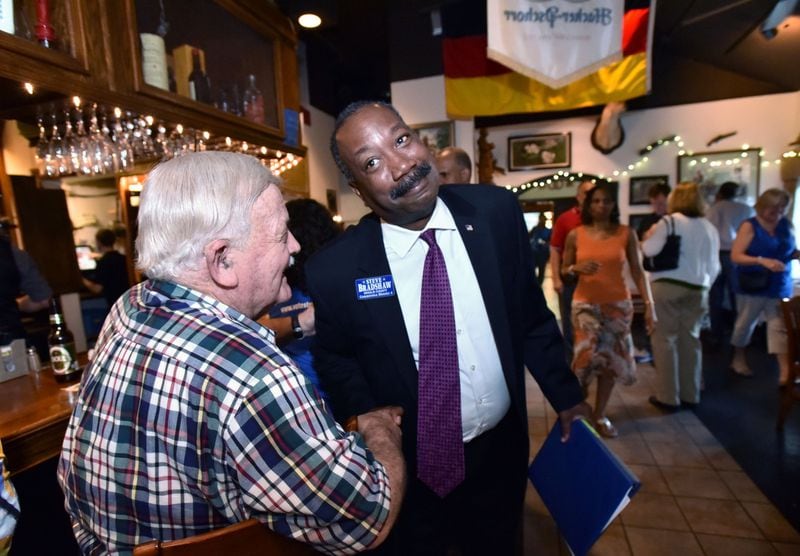 Steve Bradshaw (right) is greeted by supporter Joe Arrington in July 2016, when Bradshaw won an election to become a DeKalb County commissioner. (HYOSUB SHIN / HSHIN@AJC.COM)