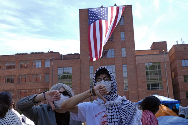 Protesters react as a giant American flag is unfurled on Lisner Hall on the campus of George Washington University in Washington, Friday, May 3, 2024, as demonstrators protest the Israel-Hamas war. (AP Photo/Susan Walsh)