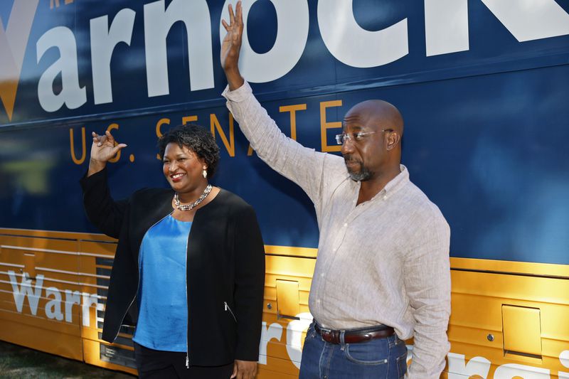 Democratic gubernatorial nominee Stacey Abrams and Democratic U.S. Sen. Raphael Warnock greet supporters during a campaign stop in Marietta on Aug. 31. (Jason Getz/The Atlanta Journal-Constitution/TNS)