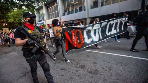 Protesters march through downtown Atlanta in September 2021 to demonstrate against the police training facility being built in unincorporated DeKalb County. 
(Jenni Girtman for The Atlanta Journal-Constitution)