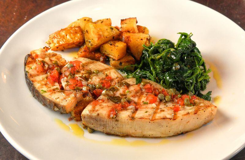 Grilled Swordfish with salmoriglio sauce, spinach and roasted potatoes at Toscano. (Chris Hunt for The Atlanta Journal-Constitution)