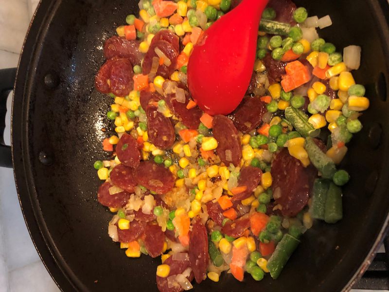 When making Fried Rice With Corn, Carrots and Chinese Sausage, it’s preferable to cook the long-grain rice the day before and refrigerate it. CONTRIBUTED BY RICHARD TANG