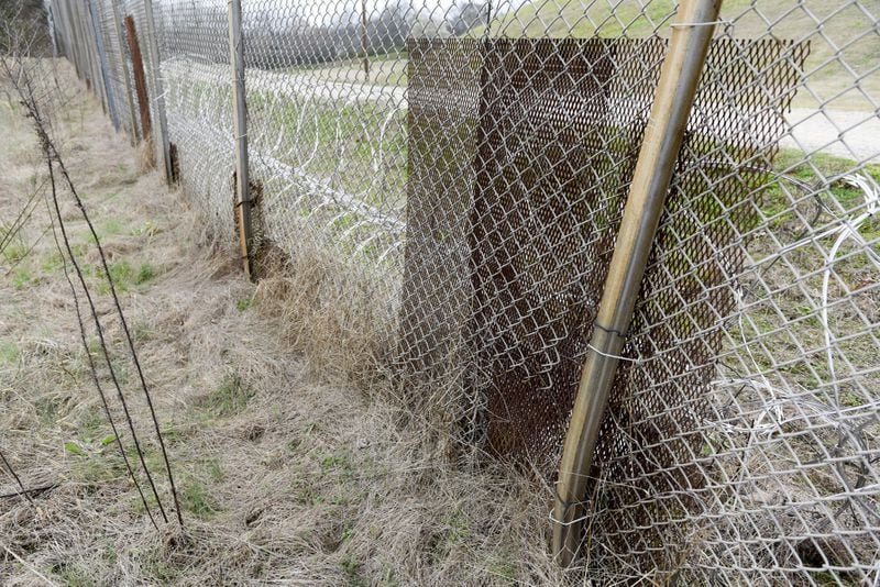 February 2017 — Patches of metal are bolted to the fence along the United States Penitentiary in Atlanta to cover holes that minimum security inmates created to sneak out and back into the prison. (DAVID BARNES / SPECIAL)