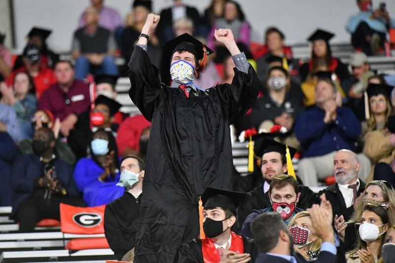 A 2020 UGA graduate celebrates in the stands at Sanford Stadium during last October's commencement ceremony. This year, students will be allowed back on the field and there is no limit to the number of guests they can invite.