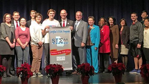 State School Superintendent Richard Woods gave Peachtree Ridge High School a banner celebrating its STEM certification.