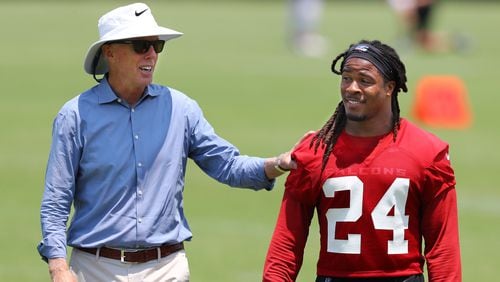 Atlanta Falcons President and CEO Rich McKay gives running back Devonta Freeman a pat  on the back during team practice on Thursday, May 23, 2019, in Flowery Branch.
