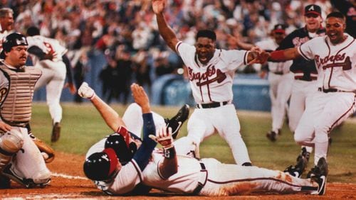 Former Brave Sid Bream, prone on the ground, gets mobbed by teammates David Justice,(on the ground with him), Ron Gant and Brian Hunter, after scoring the winning run in the bottom of the 9th inning of Game 7 of the 1992 NLCS against the Pittsburgh Pirates.