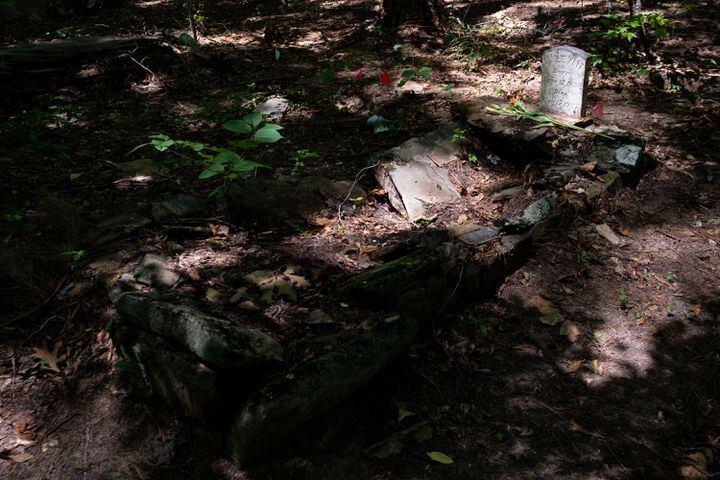 Sunlight hits one of the few marked graves at the Pierce Chapel African Cemetery in Midland, outside of Columbus, on Monday, June 20, 2022. The cemetery was rediscovered in 2019 and work has since been done to clean, document and preserve it. The cemetery, where  more than 500 African Americans and former slaves are buried, was reconsecrated during a Juneteenth celebration. Ben Gray for the Atlanta Journal-Constitution