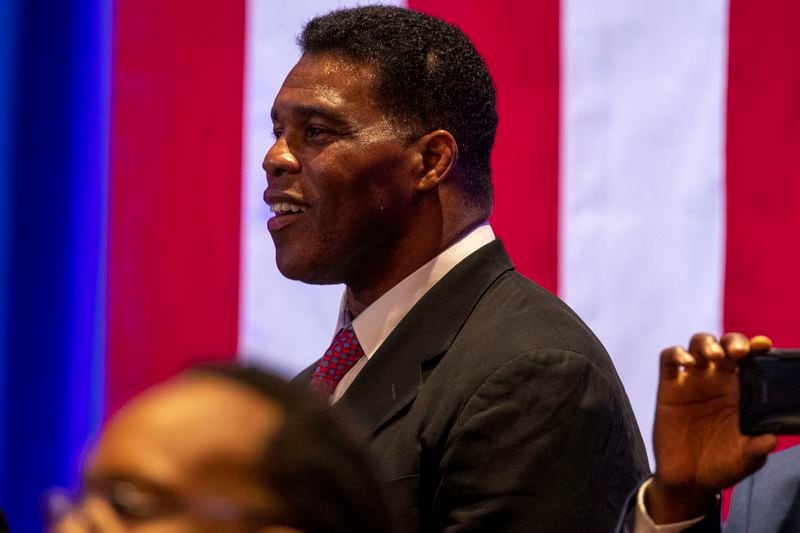 Former professional football player Herschel Walker reacts to President Donald Trump as he speaks during a Blacks for Trump campaign rally at the Cobb Galleria Centre in September. Walker and Trump have known each other for decades, and Walker spoke on the president's behalf at the 2020 Republican National Convention. (Alyssa Pointer / Alyssa.Pointer@ajc.com)