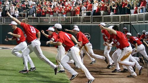 The Bulldogs charge the field to celebrate their 18-6 victory over rival Georgia Tech in their NCAA regional championship game at Foley Field in Athens on Monday.