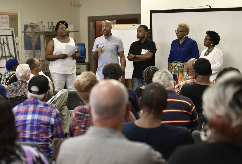 Craig Washington (standing second from left) leads a discussion about the experiences of HIV+ long-term survivors. HYOSUB SHIN / HSHIN@AJC.COM