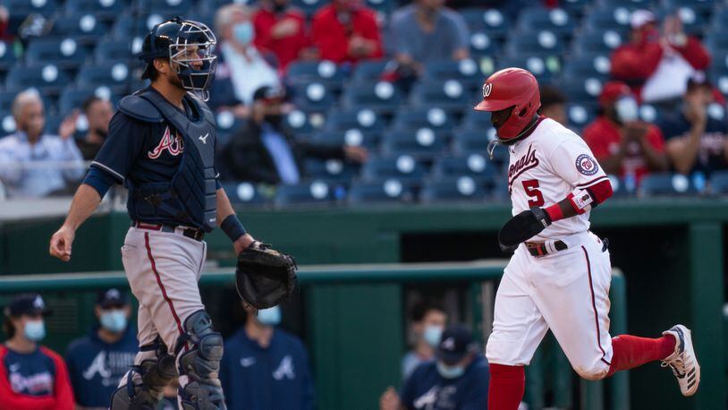 Washington Nationals' Josh Harrison (5) runs to home and score while Braves catcher Jeff Mathis watches a single hit by Nationals' Yan Gomes during the eighth inning Thursday, May 6, 2021, in Washington. (Manuel Balce Ceneta/AP)