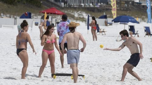 A group of spring breakers play spike ball on the beach in Destin, Fla., on Wednesday, March 18, 2020. But Atlantans can’t look forward to such fun because Okaloosa County officials voted this week to close the beaches. DEVON RAVINE / NORTHWEST FLORIDA DAILY NEWS VIA AP