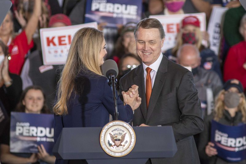 U.S. Sens. Kelly Loeffler (left) and David Perdue (right) embrace after speaking to a crowd at a rally in Gainesville, Ga., on Friday, November 20, 2020.  (Alyssa Pointer / Alyssa.Pointer@ajc.com)