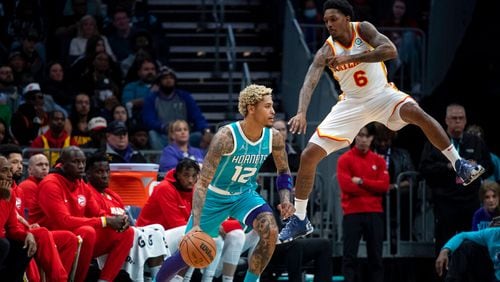 Atlanta Hawks guard Lou Williams (6) defends against Charlotte Hornets guard Kelly Oubre Jr. (12) during the second half of an NBA basketball game Wednesday, March 16, 2022, in Charlotte, N.C. (AP Photo/Matt Kelley)