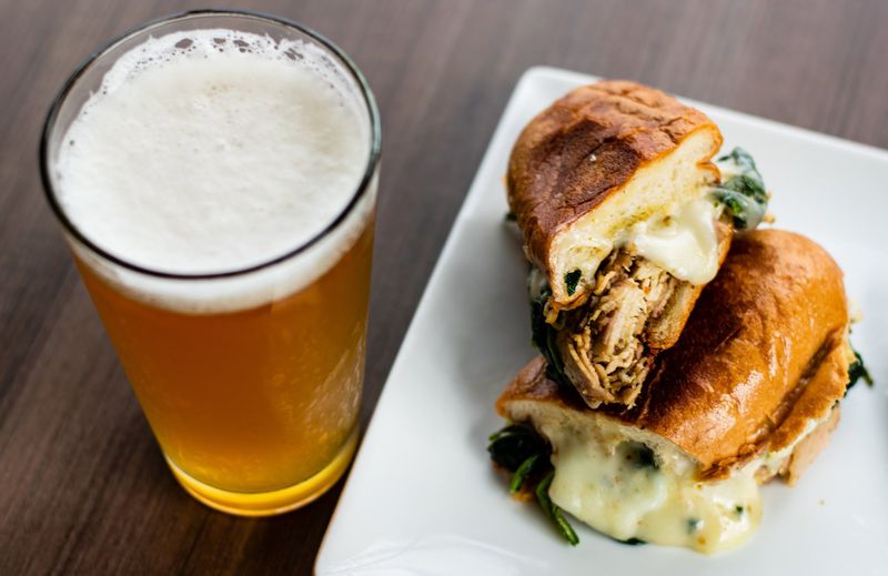 The meaty porchetta sandwich pairs well with a brew at Firepit Pizza Tavern. CONTRIBUTED BY HENRI HOLLIS