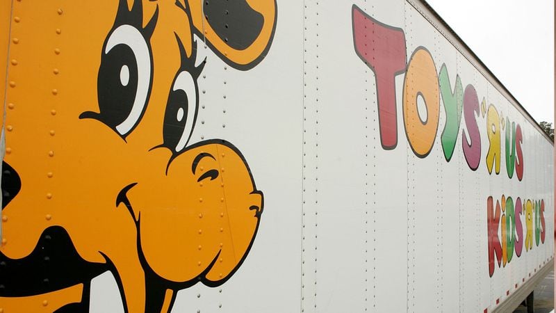 Geoffrey the Giraffe is seen on the side of a Toys 'R' Us truck. The statue that stood in the headquarters of the toy store company has a new home in a children's hospital lobby.