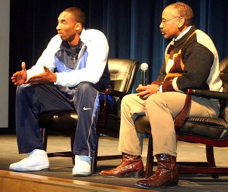 Kobe Bryant (left) sits with Columbia boys basketball coach Dr. Phil McCrary in 2007 as Bryant talks with students at the DeKalb County school. Students asked if he'd come to Columbia's boys basketball game the next night. He obliged. Photo: Mark Brock/DeKalb County Athletics