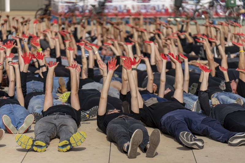 Family and supporters of hostages held in the Gaza Strip hold up their hands, painted red to symbolize blood, to call for the captives' release and to mark 200 days since the Hamas-led Oct. 7 cross-border attack, in Tel Aviv, Israel, Tuesday, April 23, 2024. (AP Photo/Ohad Zwigenberg)