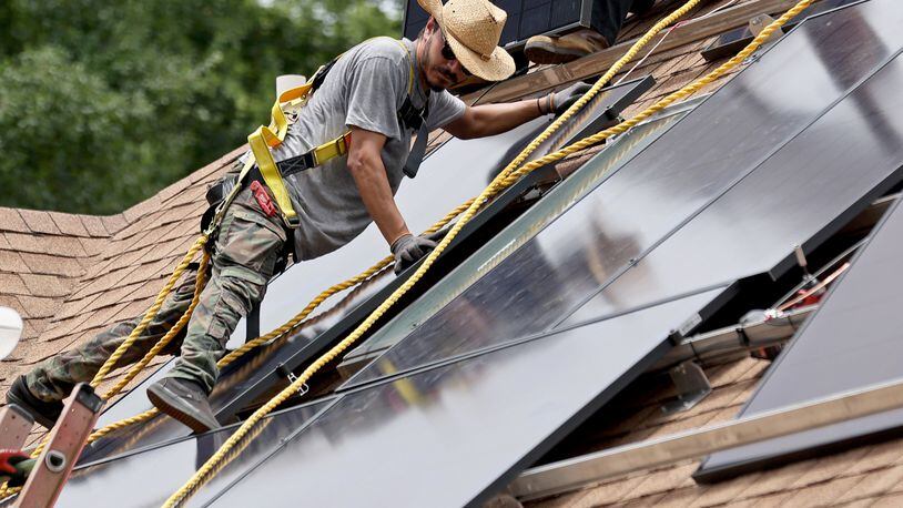 Alternative Energy Southeast employee Aaron Basto installs eighteen solar panels to the roof of a resident Tuesday, June 7, 2022, in Ellenwood, Ga. (Jason Getz / Jason.Getz@ajc.com)