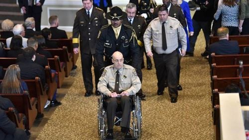 Henry County Deputy Ralph "Sid" Callaway sits in a wheelchair during Saturday’s funeral service at Glen Haven Baptist Church in McDonough for Chase Maddox.