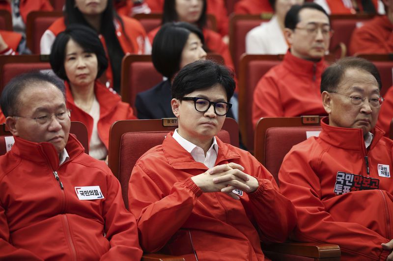 The ruling People Power Party's leader Han Dong-hoon, center, and party members watch TV broadcasting results of exit polls for the parliamentary election at the National Assembly on Wednesday, April 10, 2024 in Seoul, South Korea. (Kim Hong-Ji/Pool Photo via AP)