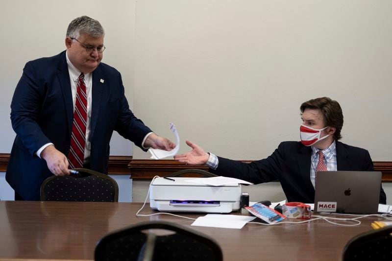 David Shafer, left, hands paperwork to an official at a Dec. 14 meeting of GOP electors at the state Capitol. (AP Photo/Ben Gray)