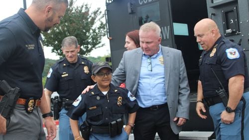 Arya Patel arrives at the Cobb County Police Training Center in a Cobb Police Department BearCat SWAT vehicle with his parents and Cobb officers for his swearing-in as a Cobb Police officer and Cobb firefighter for the day on Friday. Patel, who has osteosarcoma, wished to be a police officer for the day, and Make-A-Wish Georgia partnered with Cobb to make that wish come true.
