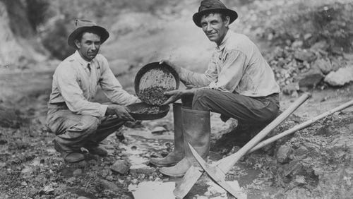 Original caption: "1933 -- The Jenkins brothers of Dahlonega, Tom (left) and William, busy with their gold pans in the famed mining section around their home. There was twenty-five cents' worth of ore in the gravel which William scooped up in his pan."