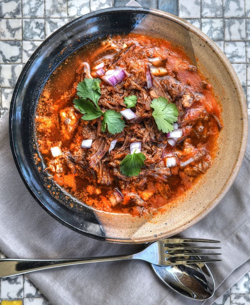 Birria de Res is served here as a stew. The meat in birria recipes can vary, but this recipe uses beef chuck roast and beef marrow bones. Styling by Kate Williams / Chris Hunt for the AJC