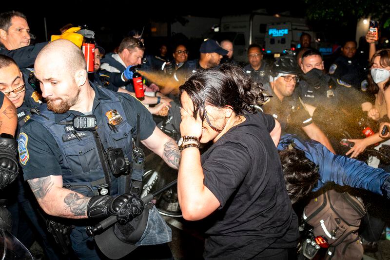 Officers of the Metropolitan Police Department pepper spray demonstrators at George Washington University, early Wednesday, May 8, 2024, in Washington. Police cleared a pro-Palestinian tent encampment at George Washington University and arrested demonstrators early Wednesday, hours after dozens marched to the home of the school’s president. (Sage Russell, GW Hatchet via AP)