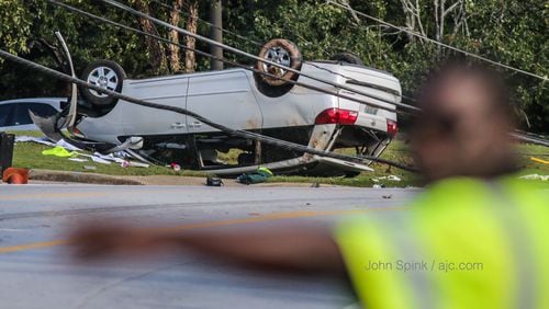 A crash knocked down a utility pole in front of Georgia Piedmont Technical College in DeKalb County on Monday. JOHN SPINK / JSPINK@AJC.COM