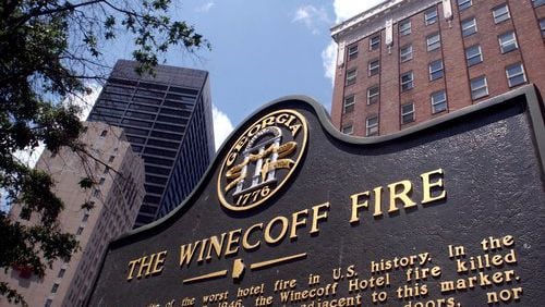 A historic marker stands in front of the old Winecoff Hotel (now the Ellis Hotel) with the Equitable Building soaring behind it on the left. The Winecoff burned on December 7, 1946, killing 119. It remains the country's worst hotel fire.