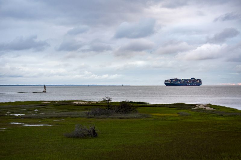 A vessel sails past Historic Cockspur Lighthouse, left, at the mouth of the Savannah River. (Stephen B. Morton for the AJC)