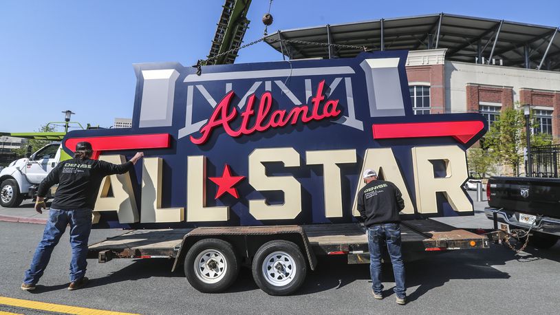 Workers load an All- Star sign after removing it from near Truist Park's scoreboard on April 6, 2021. (John Spink / john.spink@ajc.com)