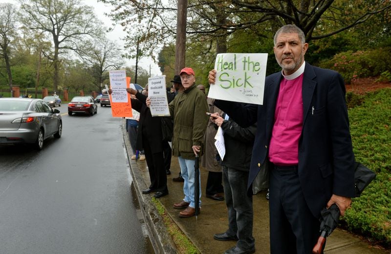 Episcopal Bishop Rob Wright joined with approximately 75 protesters, including several Atlanta clergy members and officials, in a Medicaid expansion protest outside the Governor’s Mansion in April 2014. KENT D. JOHNSON / KDJOHNSON@AJC.COM