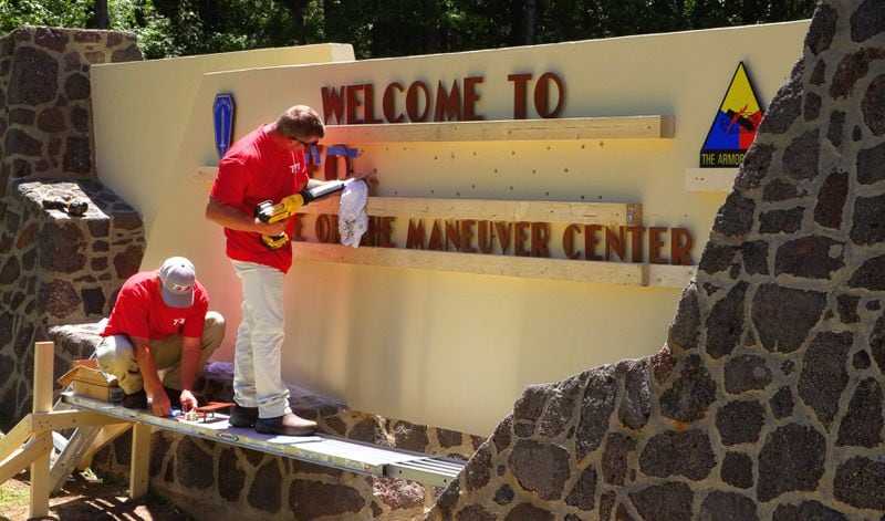 Workers change the sign at Fort Benning to the new name, Fort Moore, ahead of ceremonies on May 11, 2023 that will make the name change official. (Mike Haskey/Ledger-Enquirer)