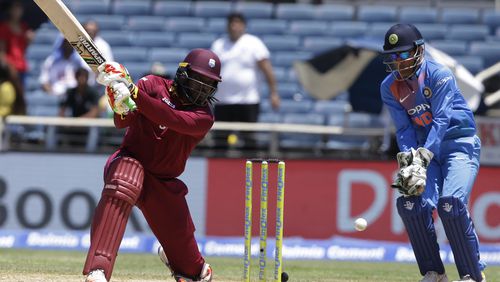 West Indies' Chris Gayle plays a shot under the watch of India's MS Dhoni during a T20I at Sabina Park cricket ground in Kingston, Jamaica, earlier this month. AP/Ricardo Mazalan