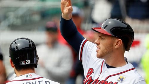 Freddie Freeman reacts after scoring on a three-run homer hit by Preston Tucker in the first inning against the Washington Nationals at SunTrust Park Wednesday, April 4, 2018, in Atlanta.