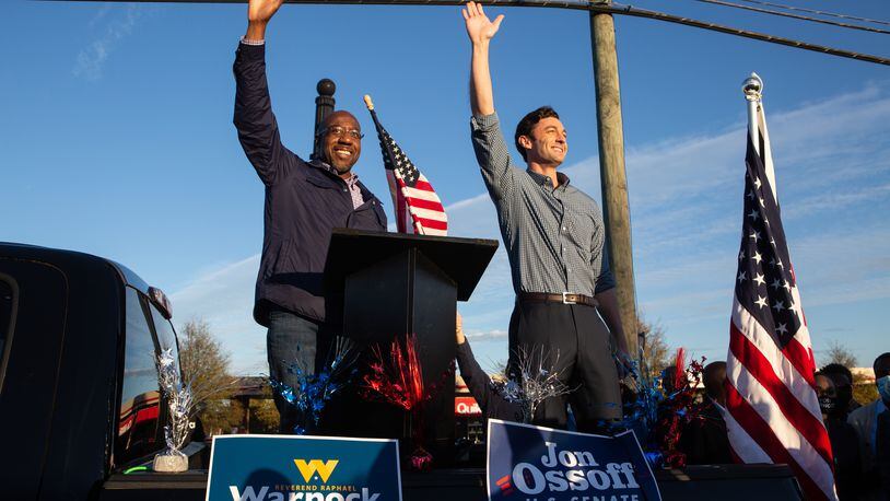 Georgia's new U.S. senators, Raphael Warnock, left, and Jon Ossoff, wave to supporters during a rally in November in Marietta. (Jessica McGowan/Getty Images/TNS)