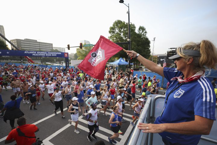 Debbie Douthit staffs the starting platform at the 53rd running of the Atlanta Journal-Constitution Peachtree Road Race in Atlanta on Monday, July 4, 2022. (Jason Getz / Jason.Getz@ajc.com)