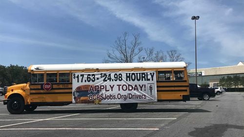 A Gwinnett County Public Schools bus sits outside the Gwinnett Place mass COVID-19 vaccination site on April 15, 2021. Gwinnett gave raises to all school bus drivers, including new hires. (Vanessa McCray / AJC)