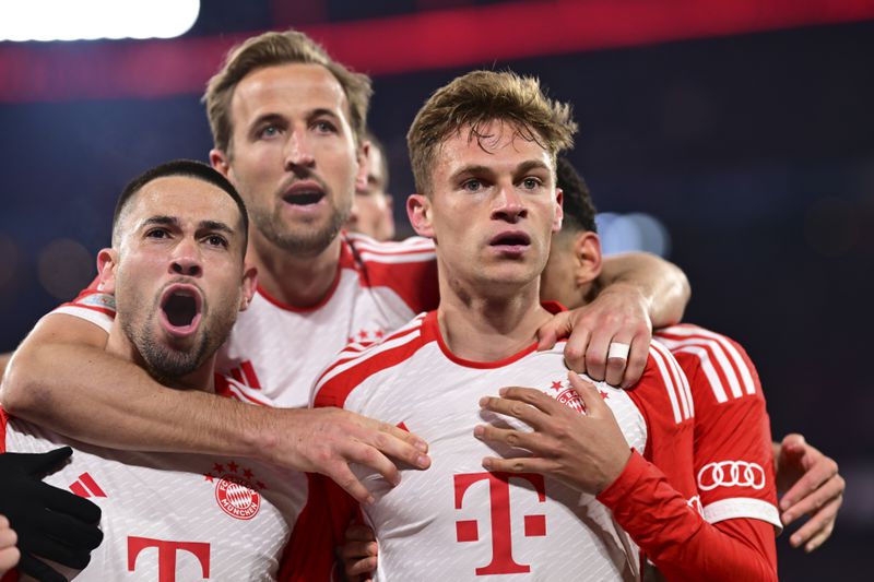 Bayern's Joshua Kimmich, right, celebrates with teammates after scoring his side's opening goal during the Champions League quarter final second leg soccer match between Bayern Munich and Arsenal at the Allianz Arena in Munich, Germany, Wednesday, April 17, 2024. (AP Photo/Christian Bruna)