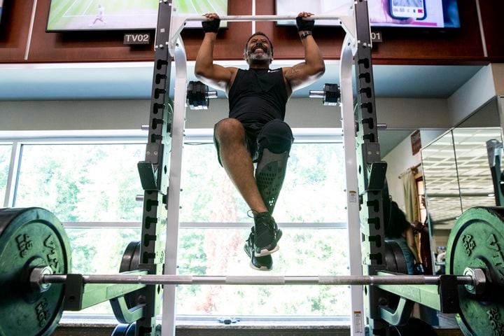 Tiran Jackson does a pull-up at Life Time Woodstock on Wednesday, July 6, 2022, in Woodstock, Georgia. Jackson said fitness is important to him to ensure he can continue to walk and maintain his balance with his leg and prosthetic. (Chris Day/Christopher.Day@ajc.com)