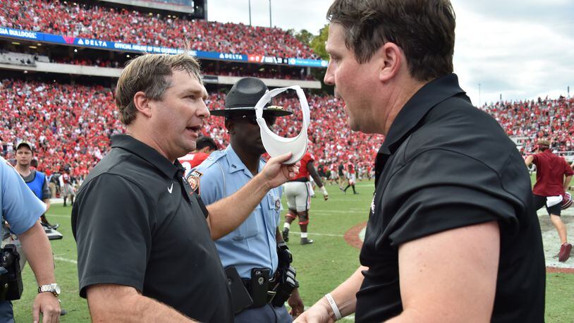 Georgia coach Kirby Smart (left) and South Carolina  coach Will Muschamp shake hands after South Carolina defeat the Georgia in double overtime during a NCAA college football game at Sanford Stadium in Athens on Oct. 12.  They were teammates at Georgia in the 1990s and coached together on Valdosta State's staff in 2000.  (Hyosub Shin / Hyosub.Shin@ajc.com)