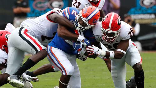 A pack of Bulldogs combine to stop Florida running back Lamical Perine Saturday in Jacksonville. (BOB ANDRES / ROBERT.ANDRES@AJC.COM)