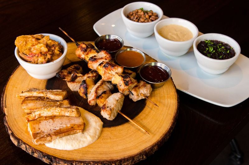 The Pig Trio at Todd English Tavern is served family-style, with crispy pork belly, pulled pork and charred pork tenderloin skewers. CONTRIBUTED BY HENRI HOLLIS